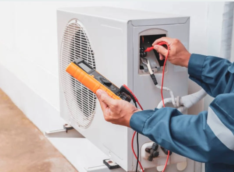 Technician testing an outdoor HVAC unit with a multimeter